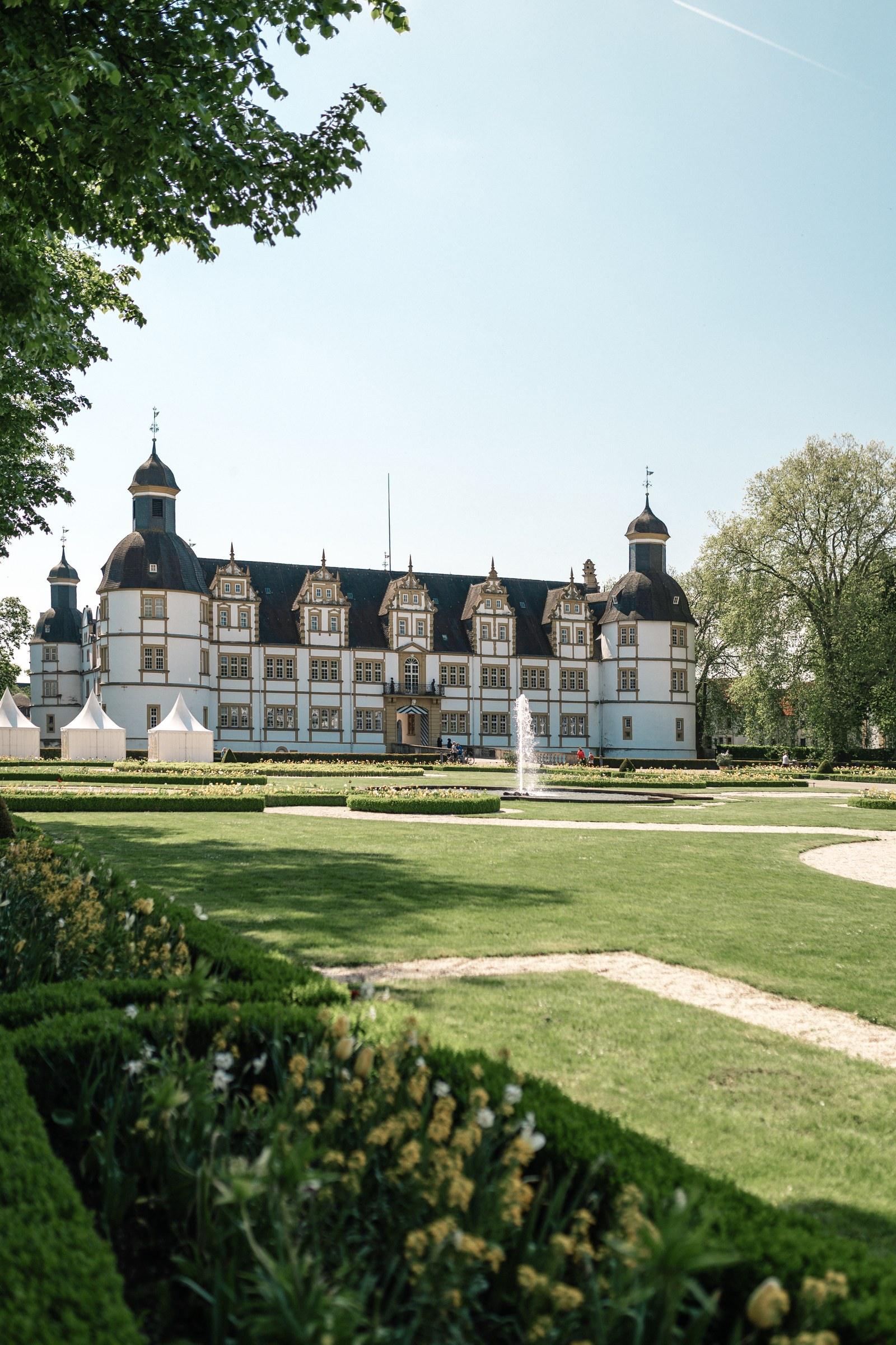 Schloss Neuhaus in Paderborn mit Barockgarten und blauem Himmel