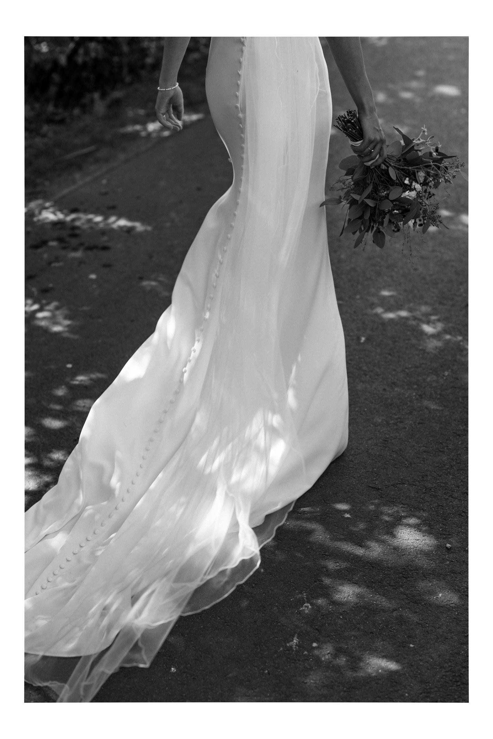 Das Brautkleid mit langer Schleppe im Schatten der Bäume, Schwarzweiß